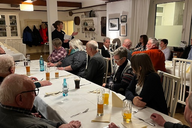 Mehrere Personen sitzen an einem Tisch.