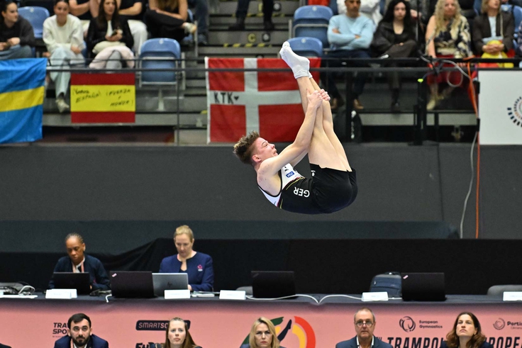 Ein Turner macht seine Übung in der Luft