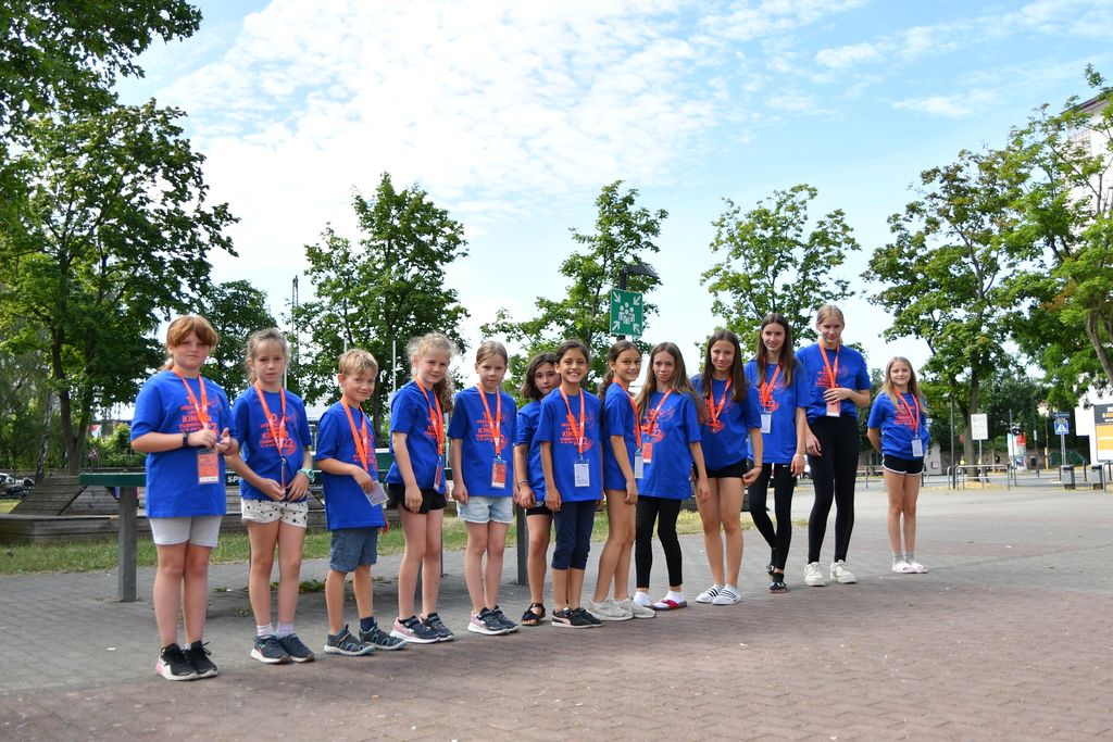 Mehrere Kinden stehen im Turnfest-T-Shirt in einer Reihe aufgestellt auf einem Schulhof.