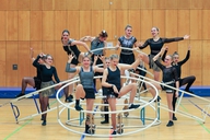 Eine Gruppe von Sportlerinnen steht an ihren Rhönrädern