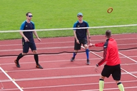 Drei Personen spielen Ringtennis. 