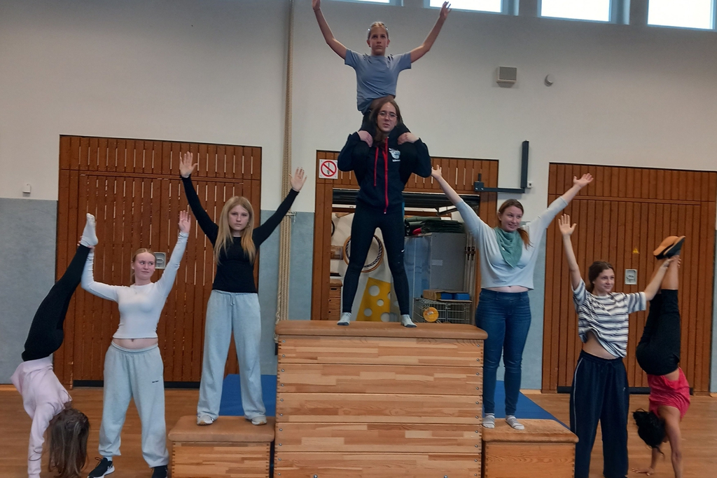 Mehrere Personen zeigen gemeinsam eine menschliche Pyramide.