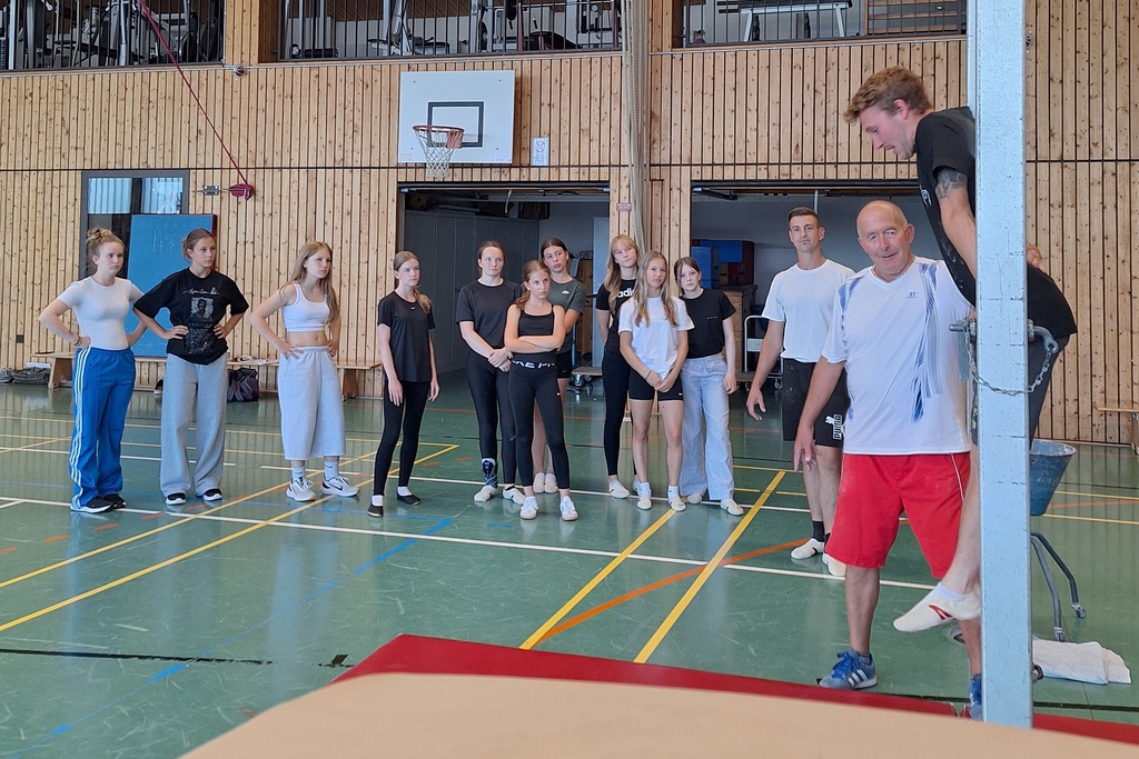 Eine Gruppe schaut auf einen Trainer der eine Übung erklärt.