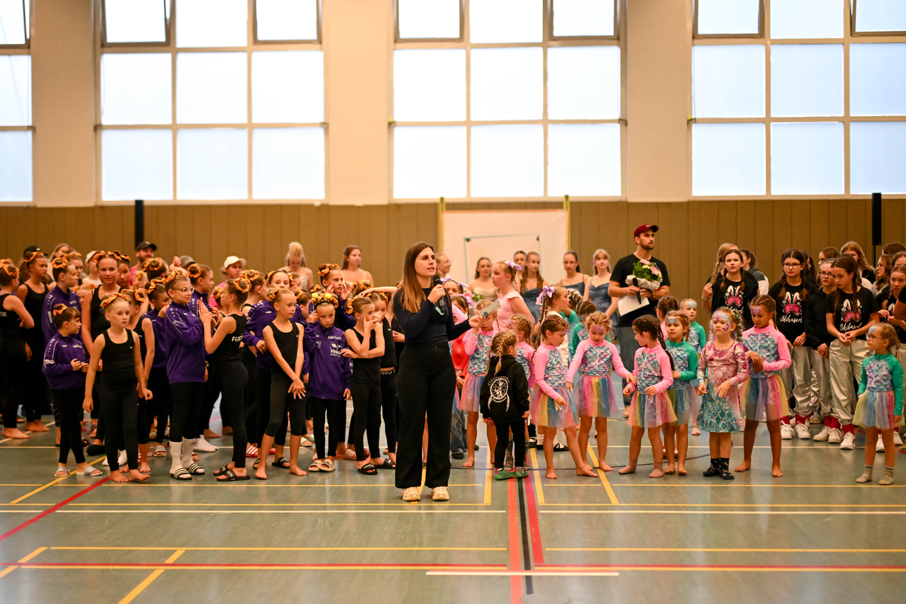 Viele Showgruppen stehen auf der Tanzfläche und blicken ins Publikum.