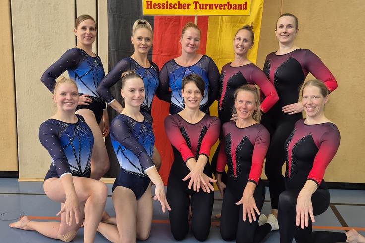 Ein Team aus 10 Turnerinnen posiert für ein Foto.
