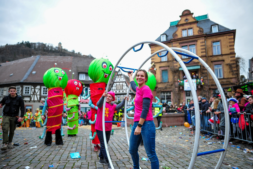 Ein bunter Festumzug mit vielen Teilnehmenden durch eine Altstadt.
