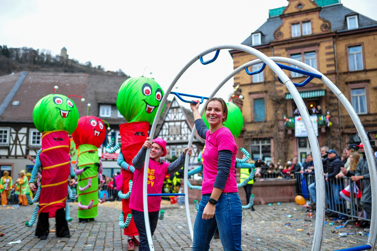 Ein bunter Festumzug mit vielen Teilnehmenden durch eine Altstadt.