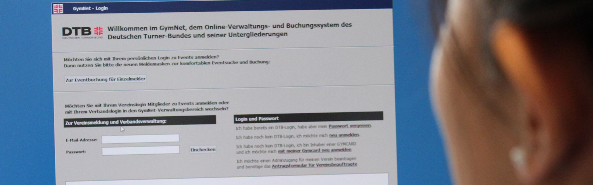 Eine Frau schaut auf einen Bildschirm auf dem die Anmeldung des GymNet zusehen ist.