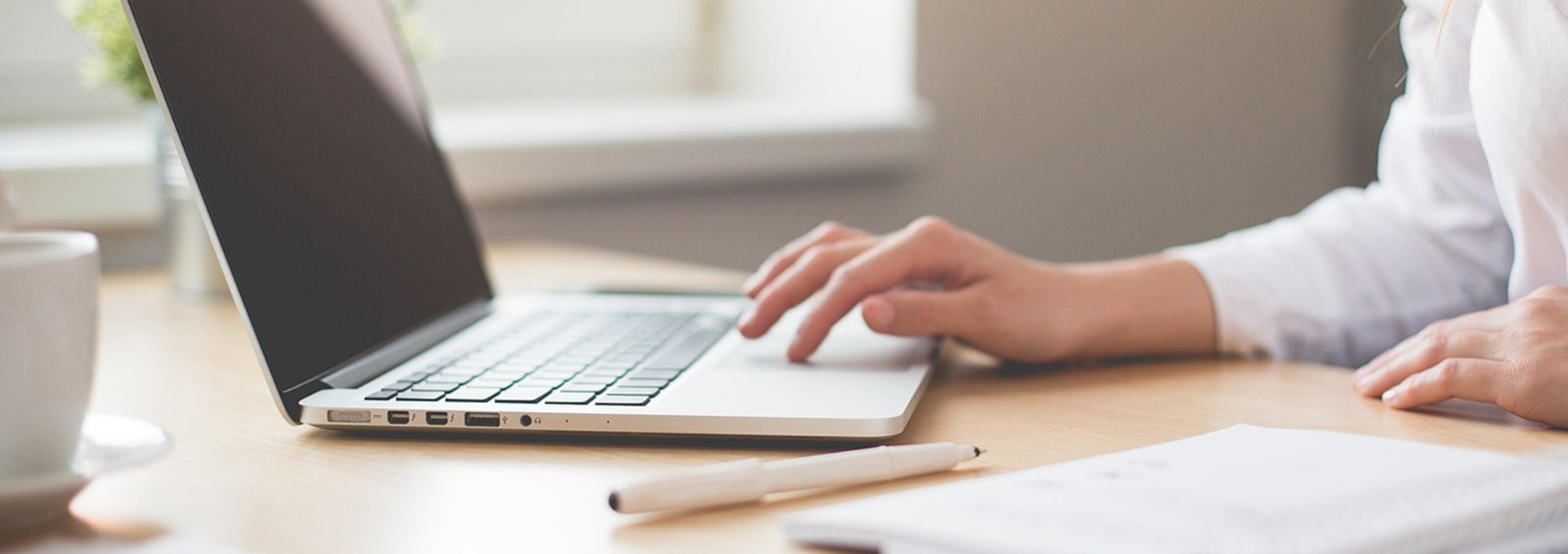 Ein Bildausschnitt mit einer Frau an einem Laptop.
