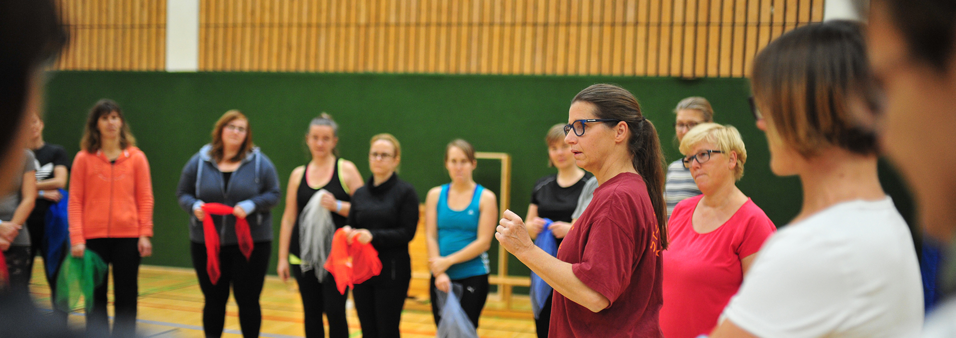 Eine Frau erklärt einer Gruppe, die im Kreis zusammen steht, etwas.