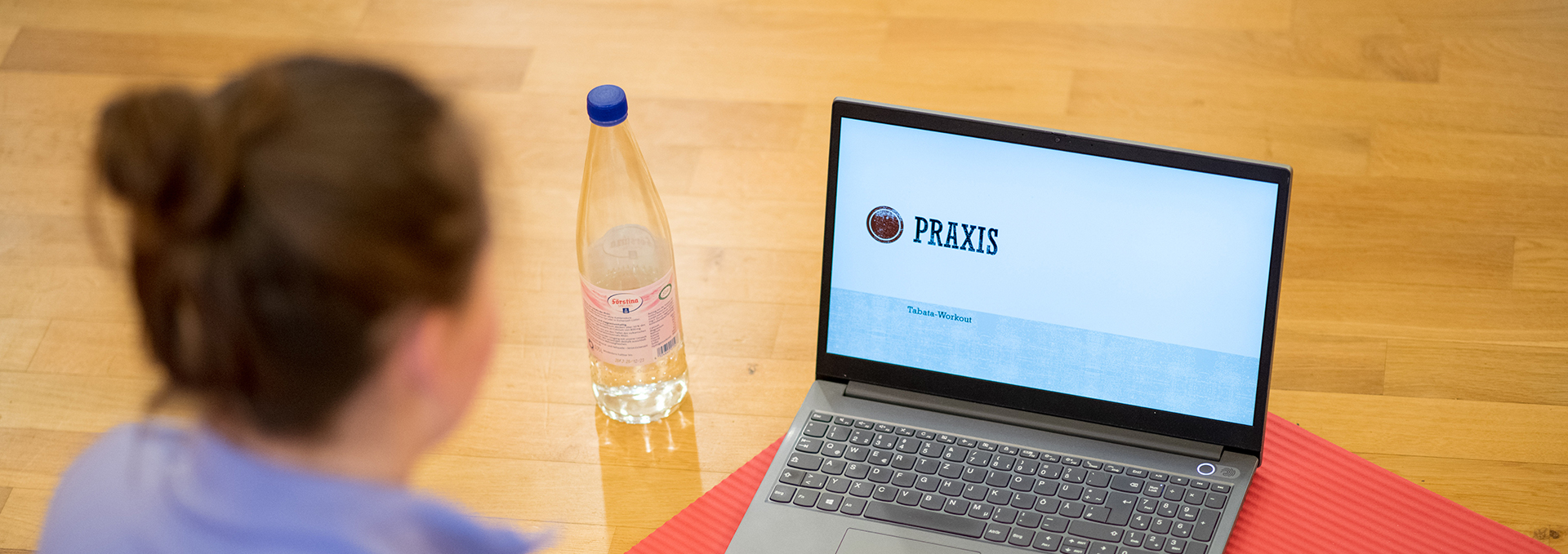 Eine Frau sitzt vor einem Laptop.