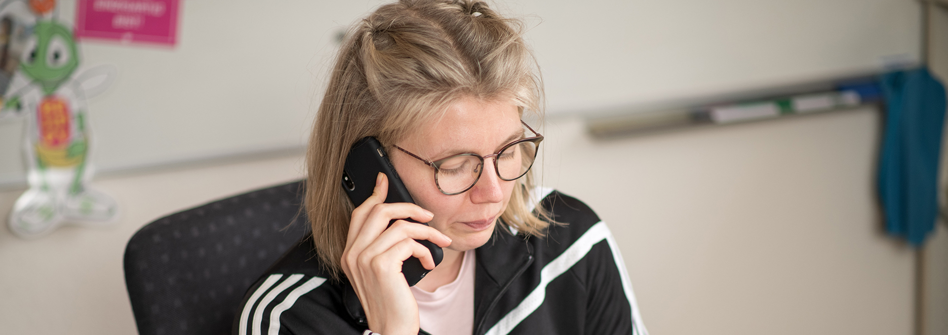 Eine Frau sitzt an einem Schreibtisch und telefoniert.