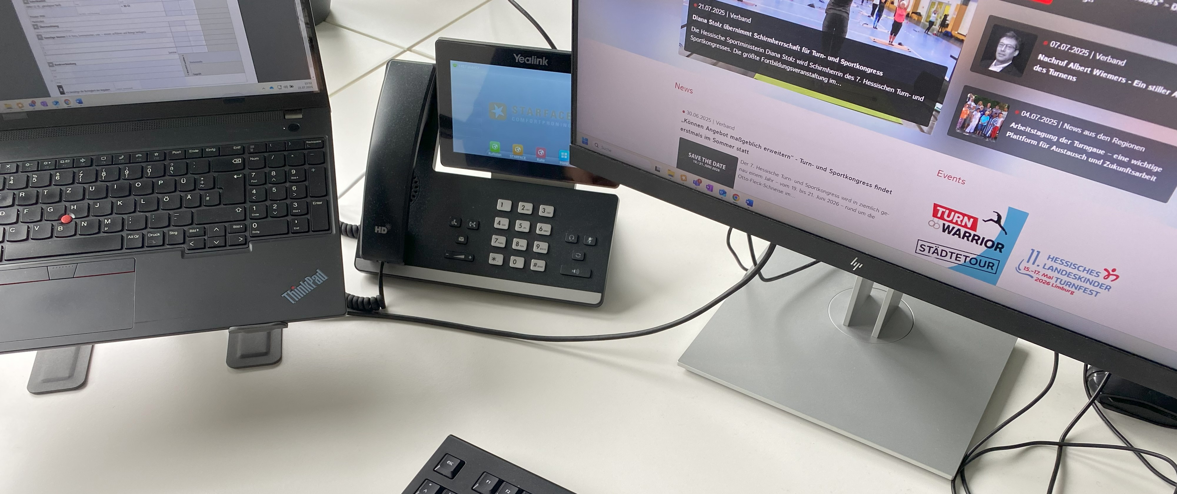 Sie sehen Teile eines Laptops, eines Telefons und eines Bildschirms. 