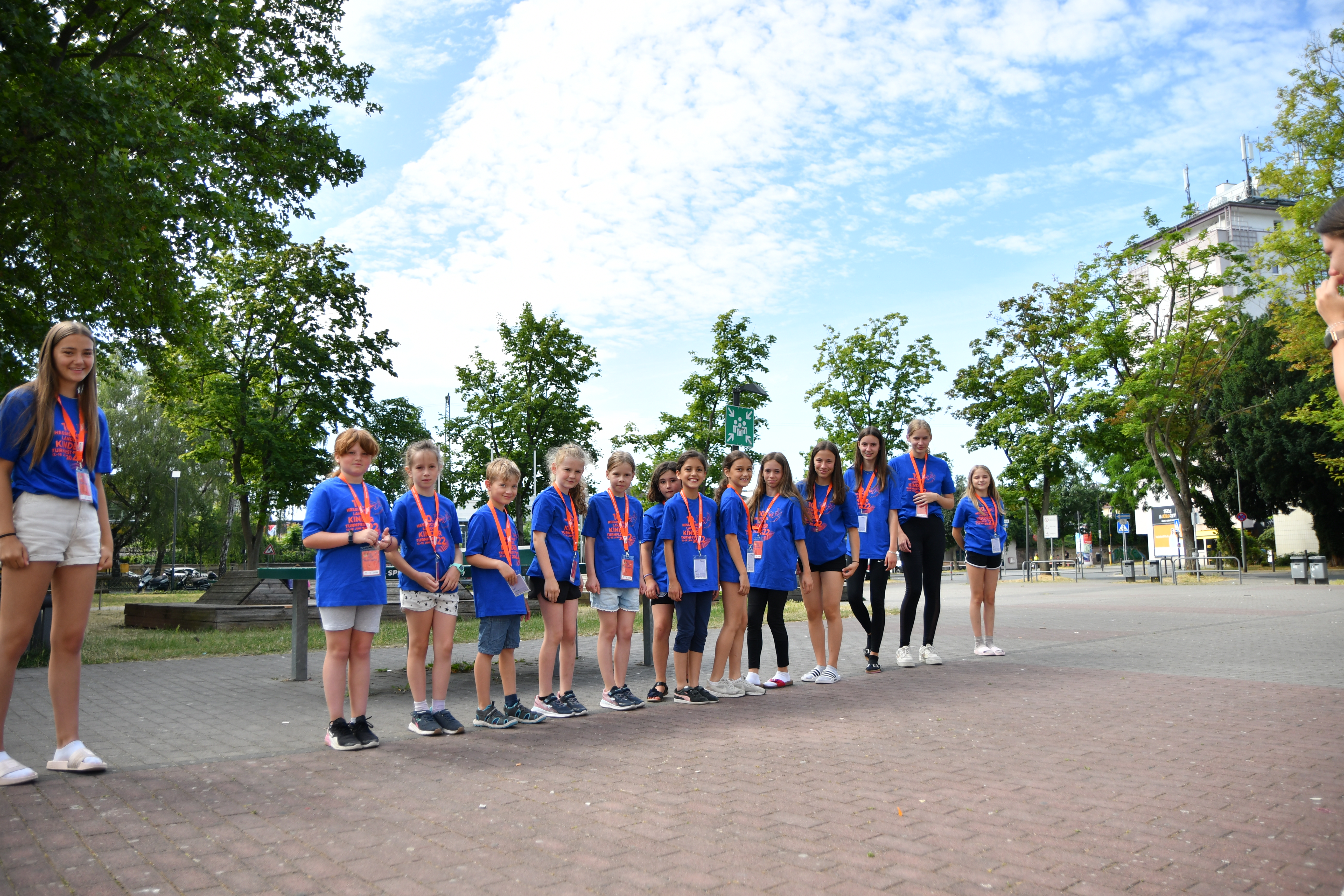 Mehrere Kinden stehen im Turnfest-T-Shirt in einer Reihe aufgestellt auf einem Schulhof.