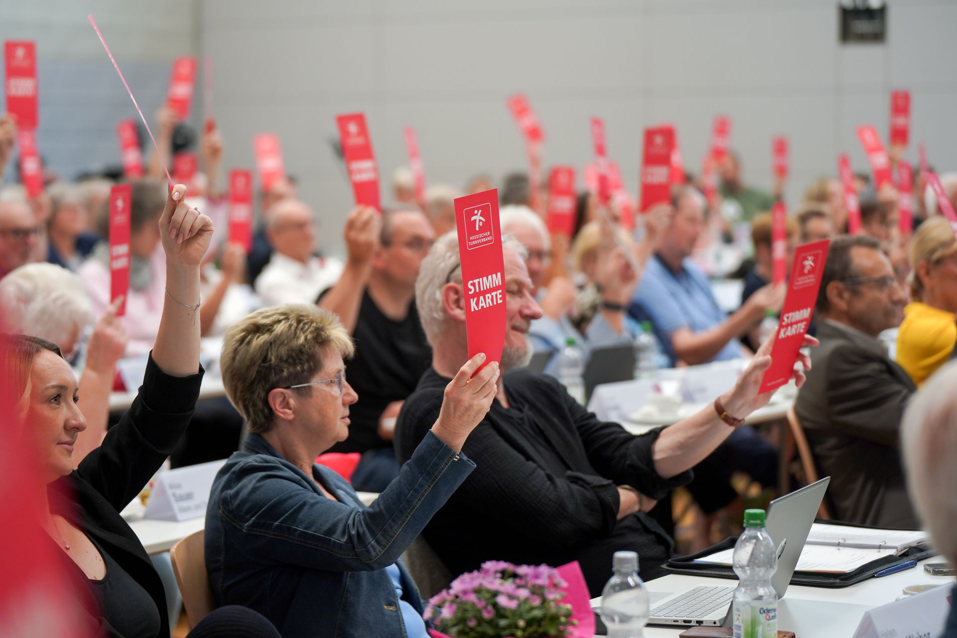 Die Delegierten heben ihre rote Stimmkarte